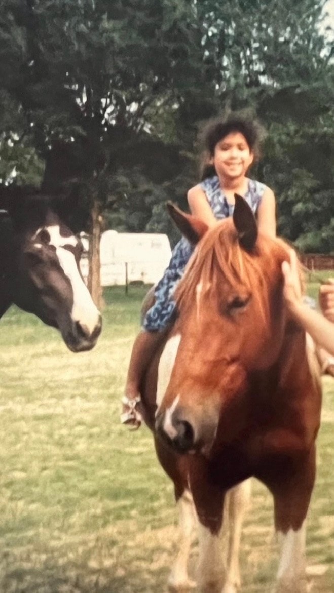 Young girl riding a horse outdoors